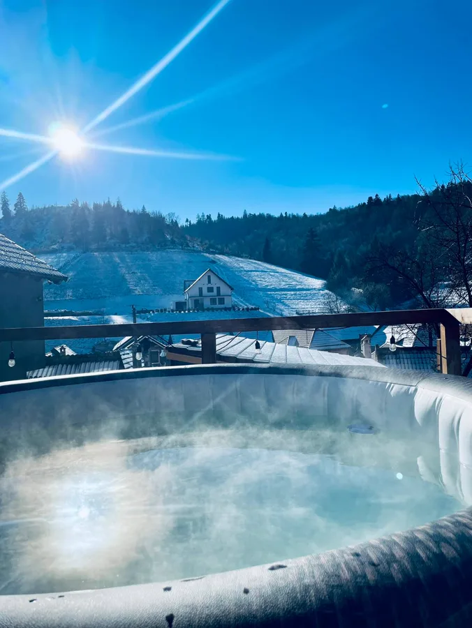 Jacuzzi cu aburi în soare de iarnă — relaxare pură la zăpadă